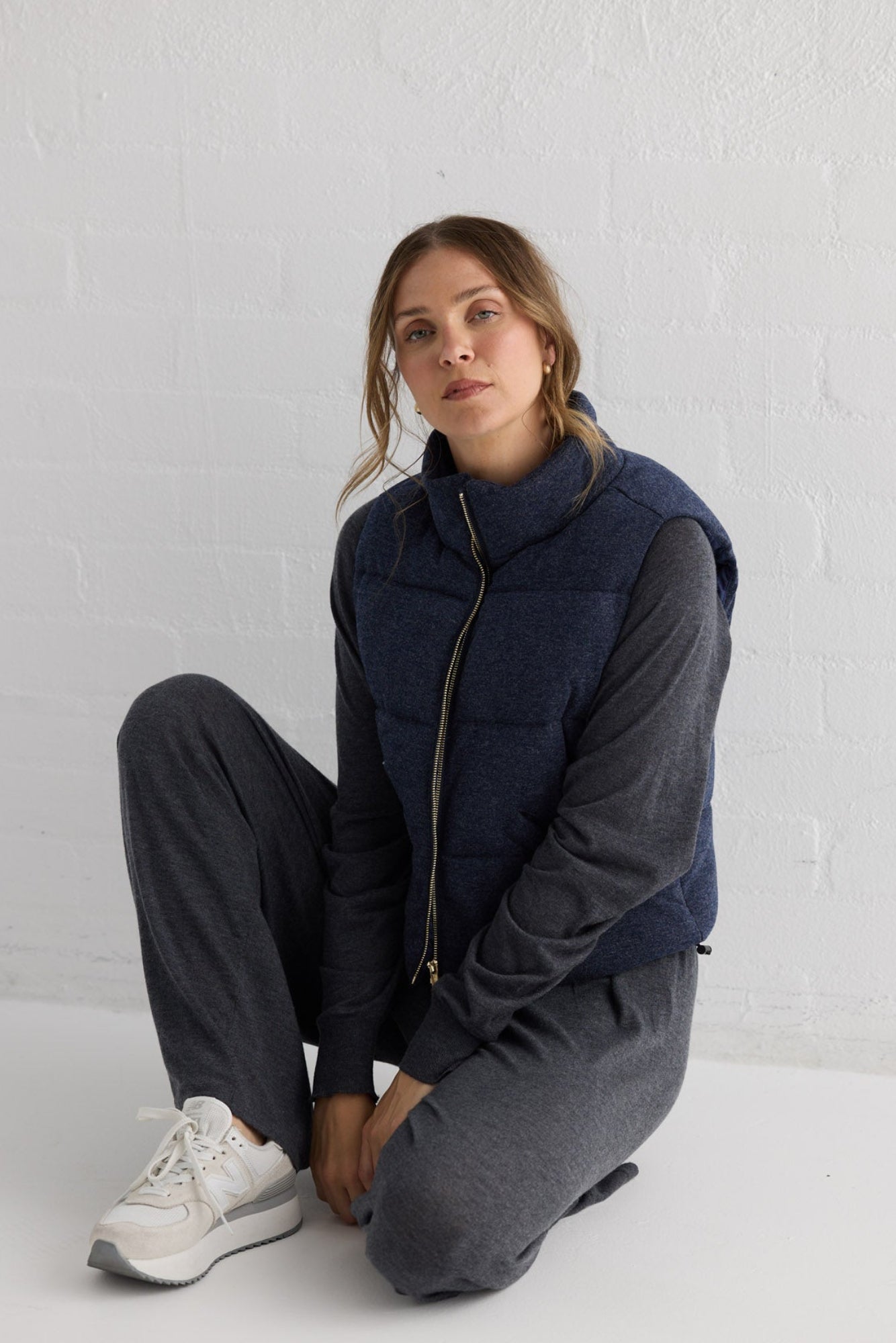 Campaign image of model wearing Tate Puffer Vest in navy.