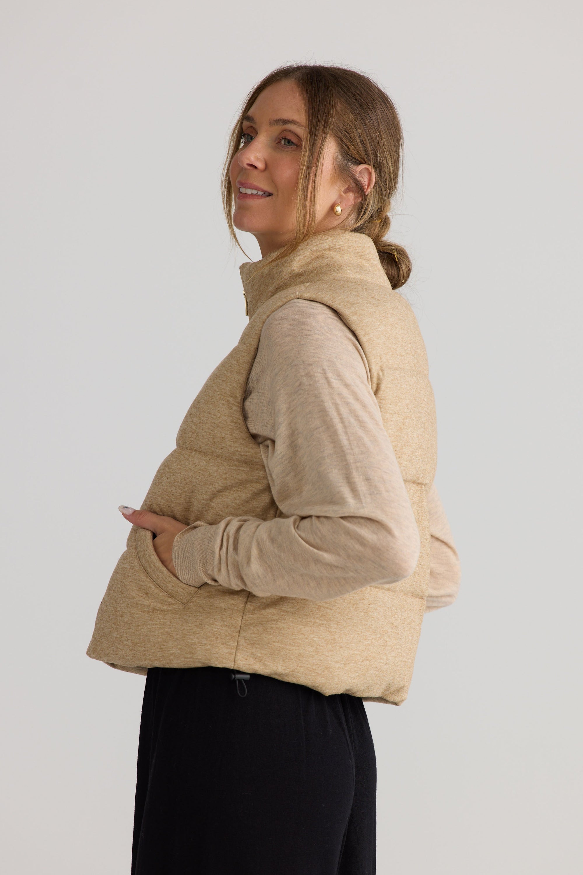 Model wearing Tate Puffer Vest in oat.