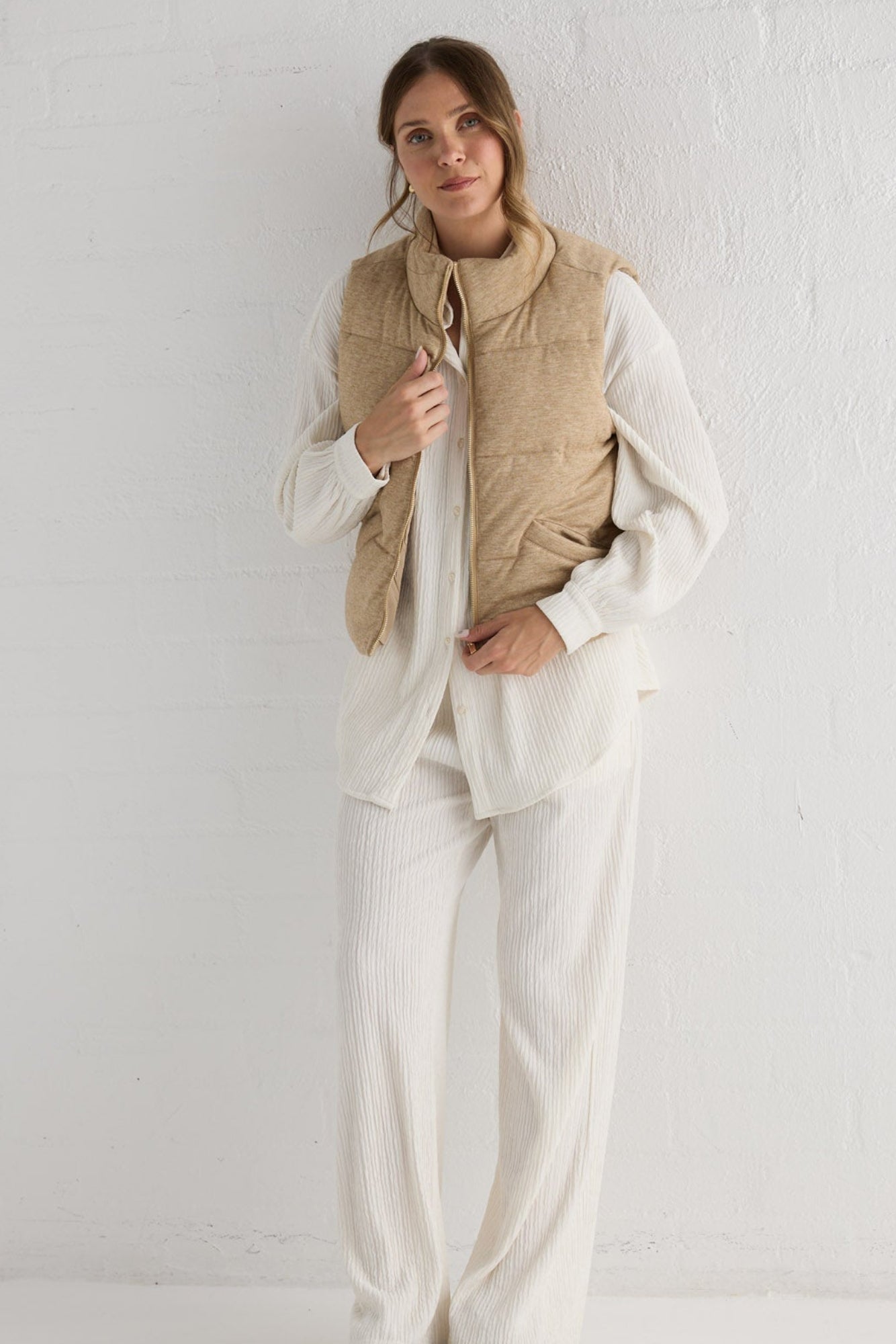 Campaign image of model wearing Tate Puffer Vest in oat.