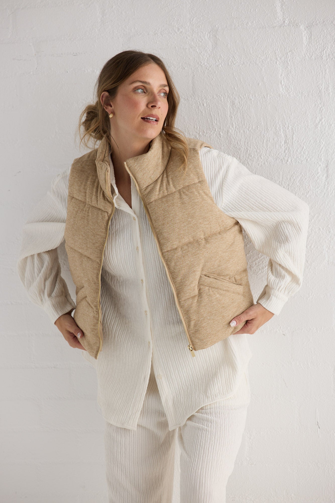 Campaign image of model wearing Tate Puffer Vest in oat.