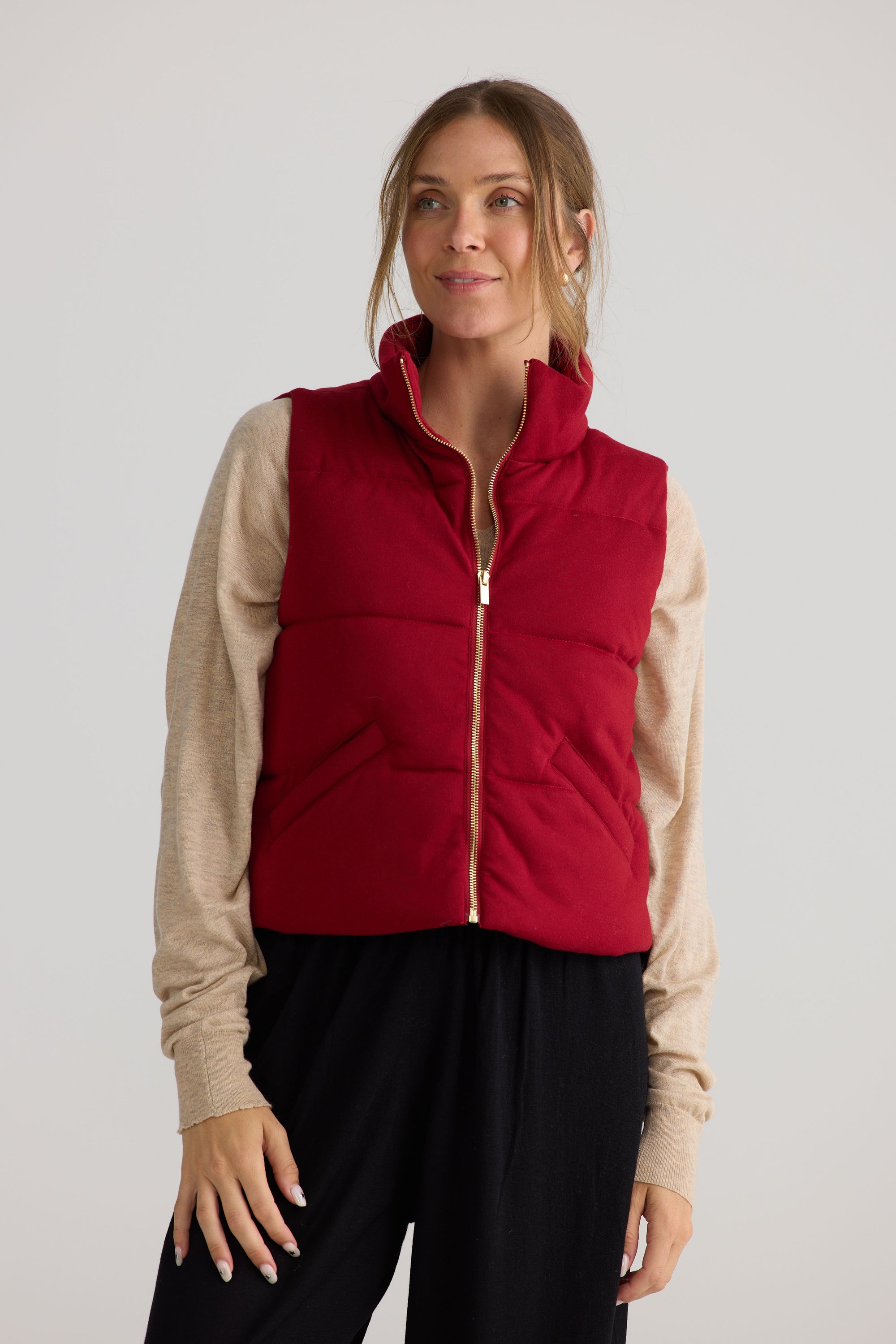 Model wearing Tate Puffer Vest in red, showing puffer quilting.
