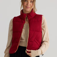 Model wearing Tate Puffer Vest in red, styled for everyday wear.