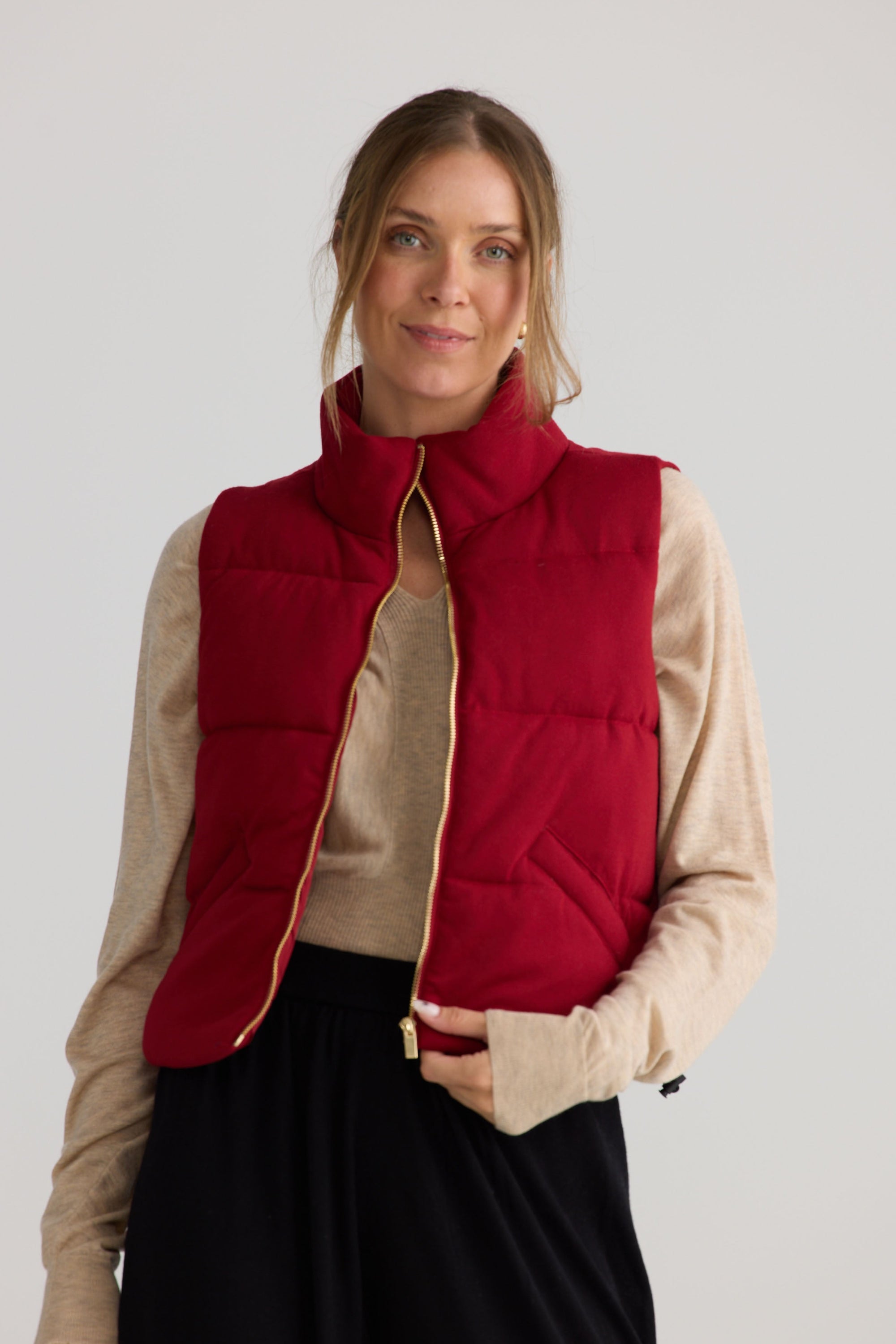 Model wearing Tate Puffer Vest in red, styled for everyday wear.