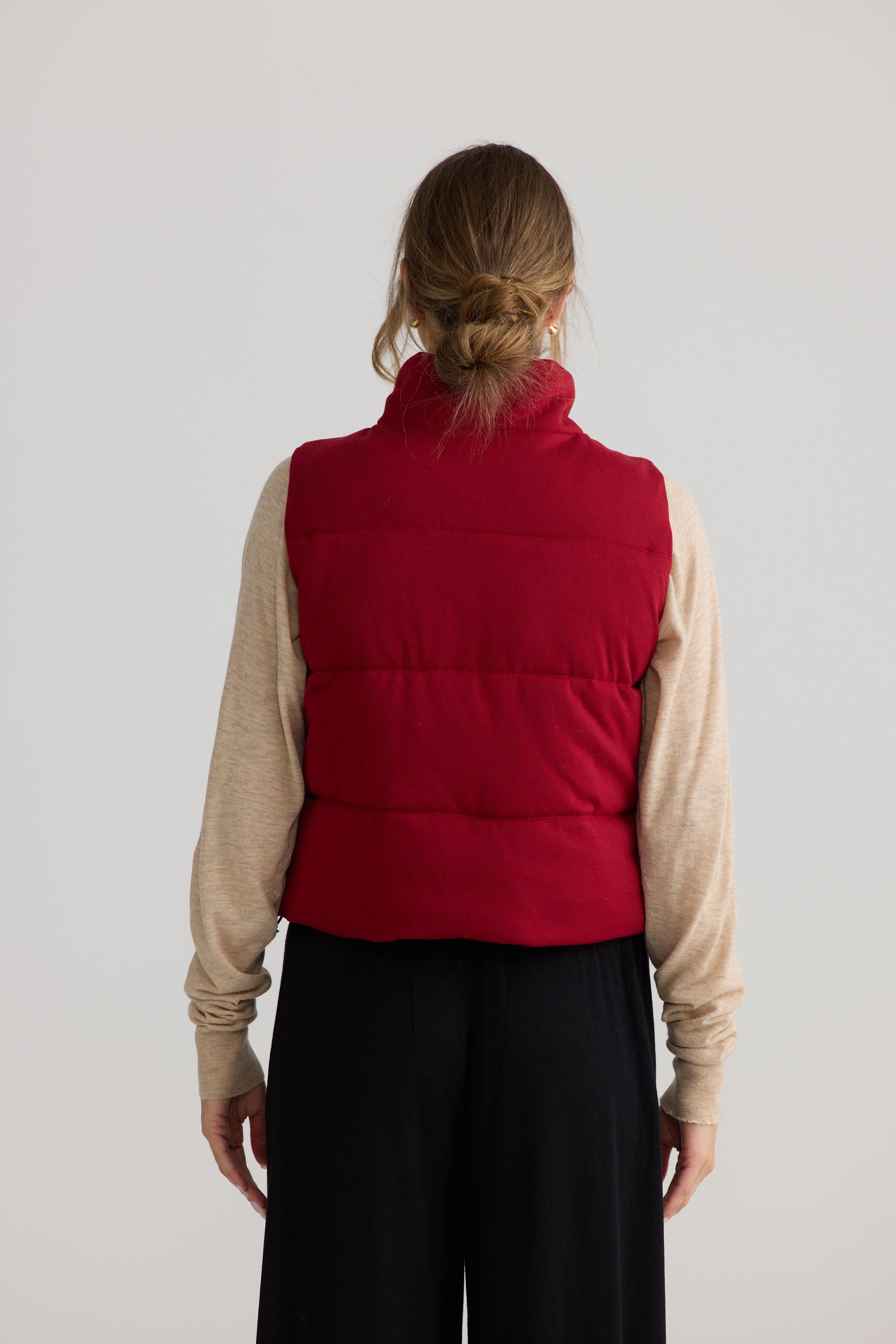 Model wearing Tate Puffer Vest in red.