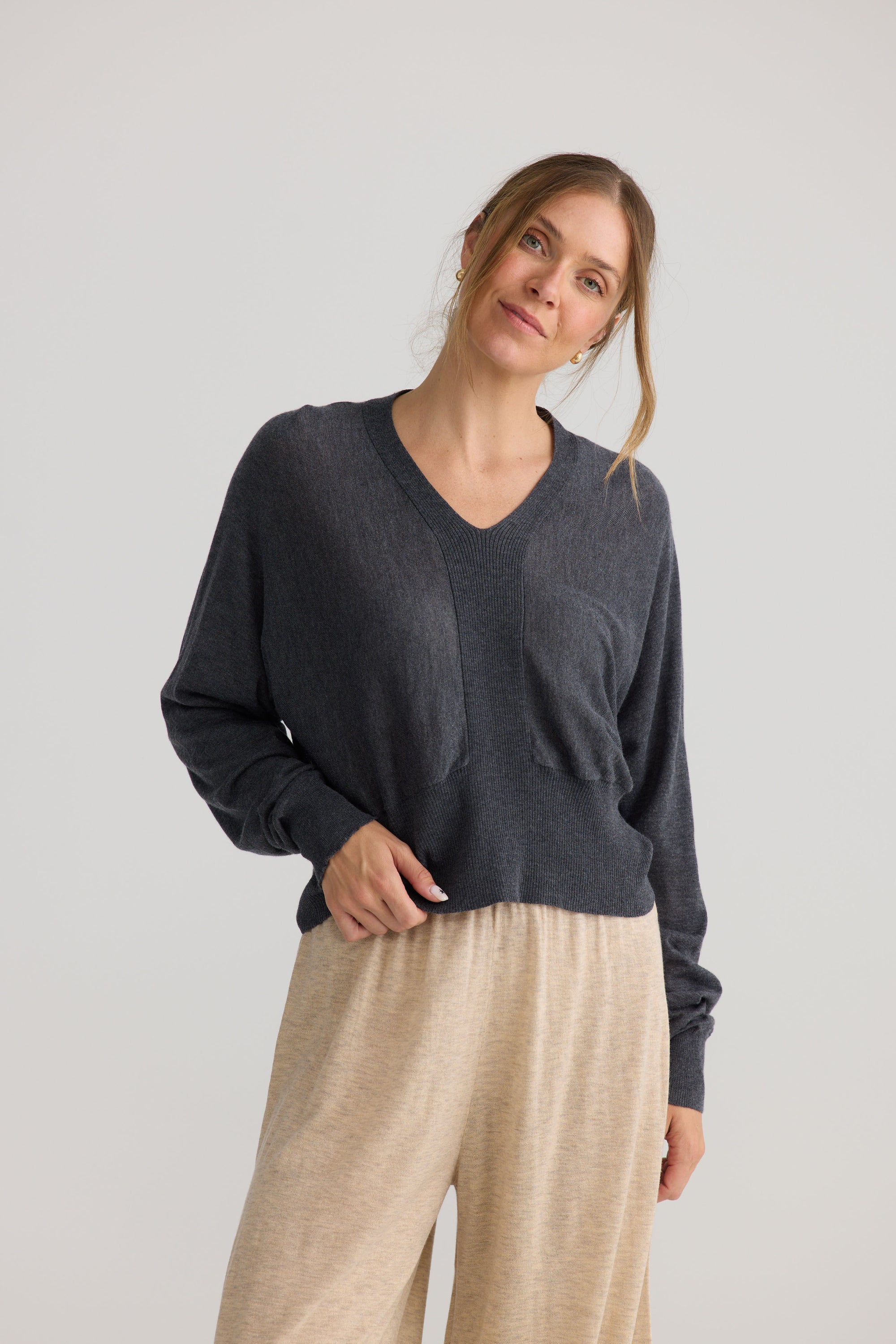 Model wearing Stillness Knit in charcoal, showing knit texture.
