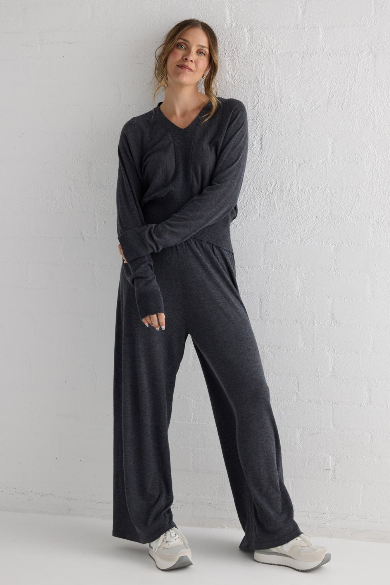 Campaign image of model wearing Stillness Knit Pant in charcoal.