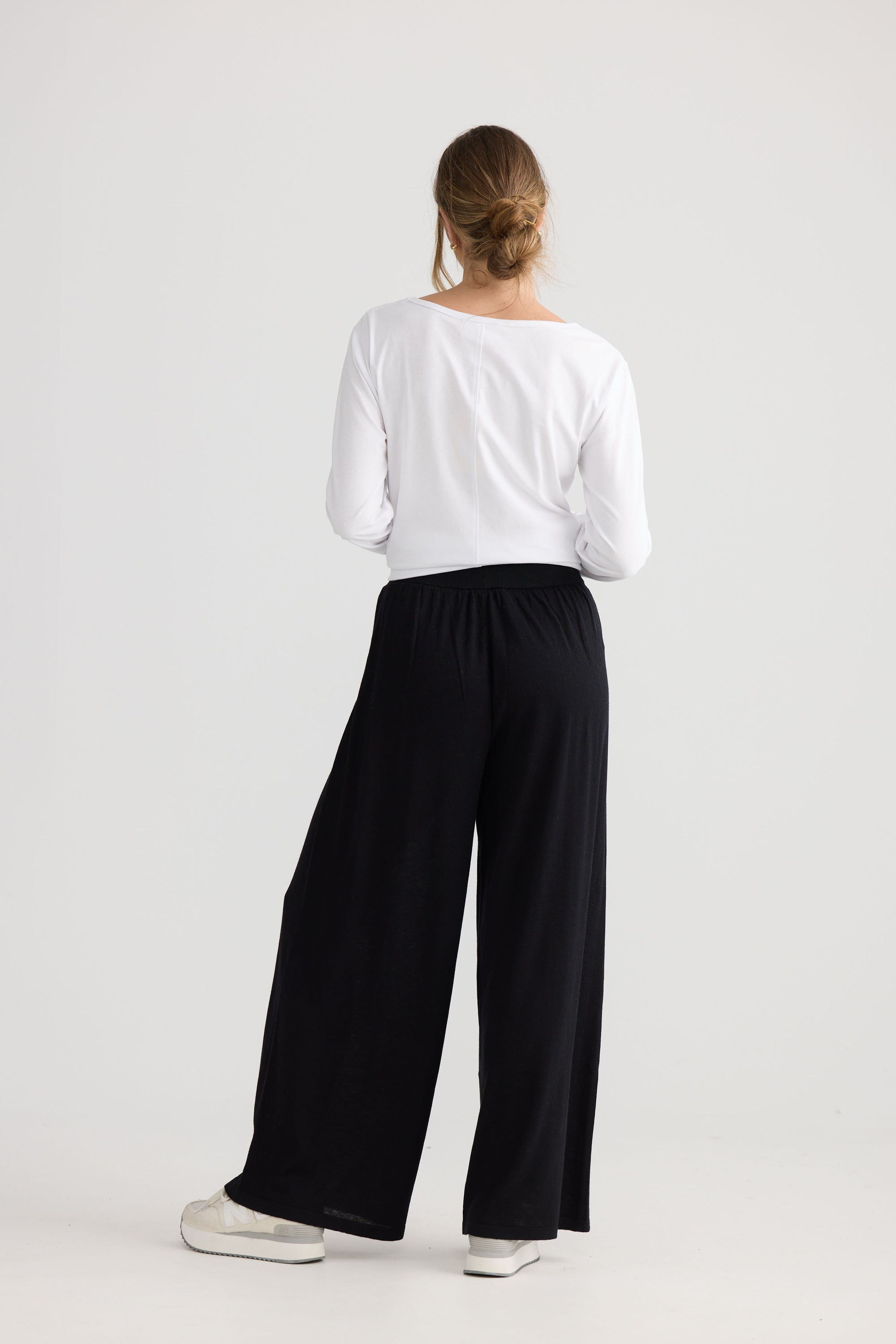 Model wearing Stillness Knit Pant in black, showing relaxed leg shape.