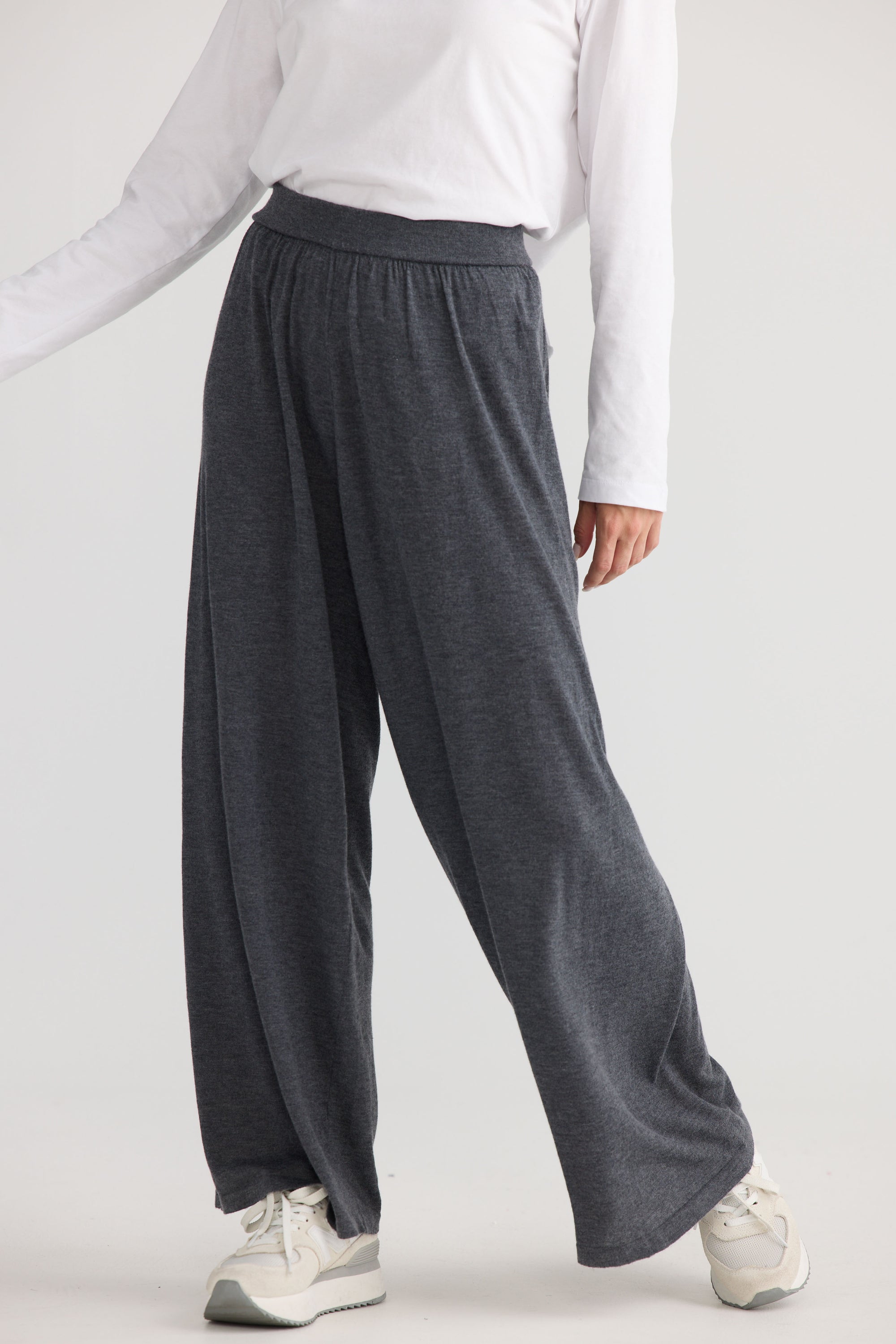 Model wearing Stillness Knit Pant in charcoal, showing relaxed leg shape.