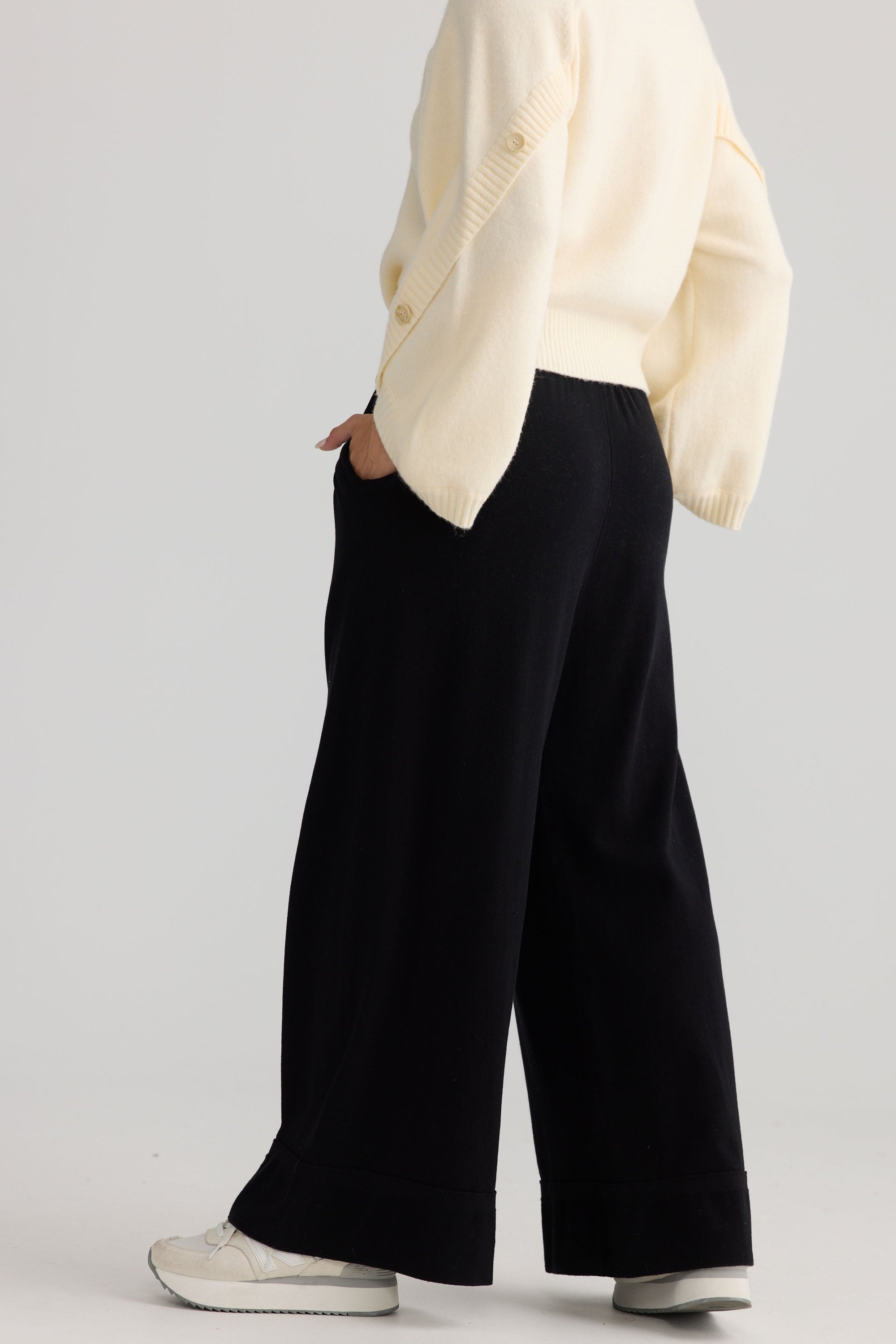Model wearing Awaken Knit Pant in black, styled for everyday wear.